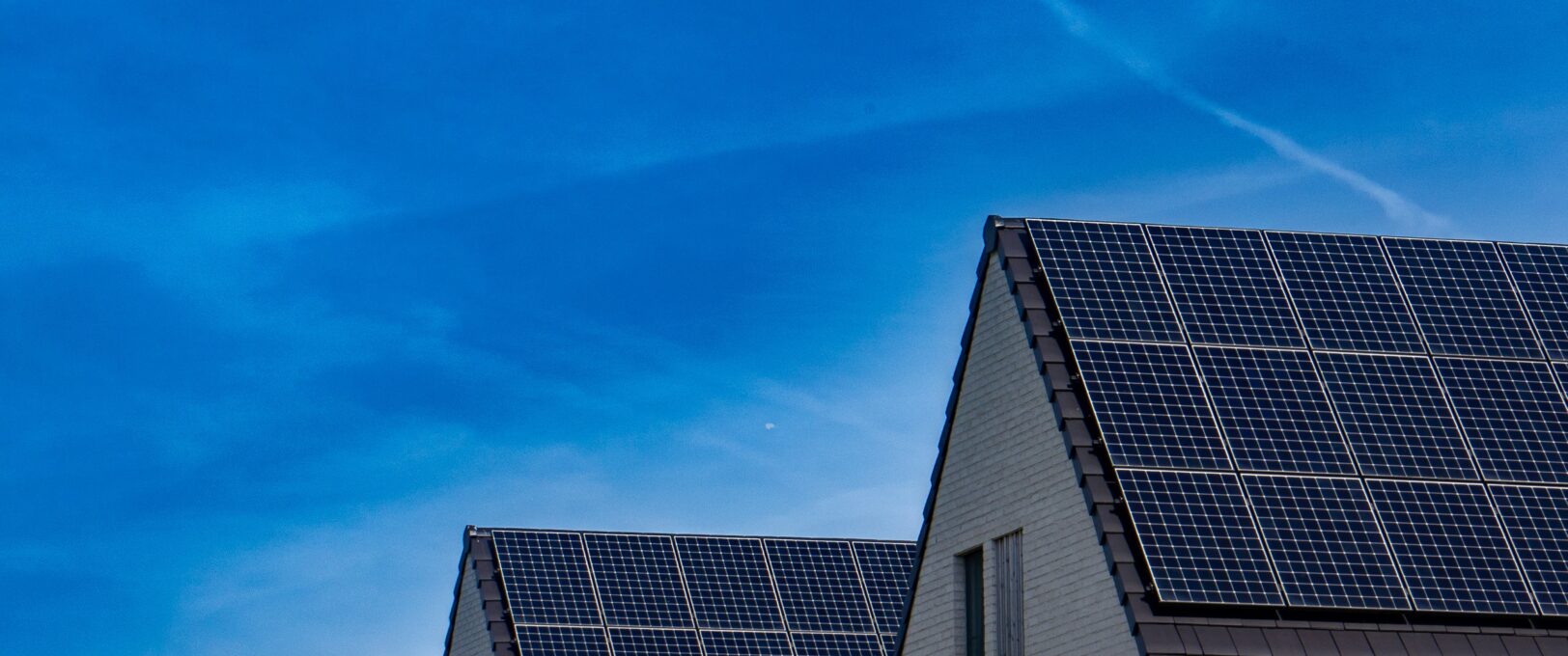 Solar panel installers discussing work on site with panels and blue sky in background